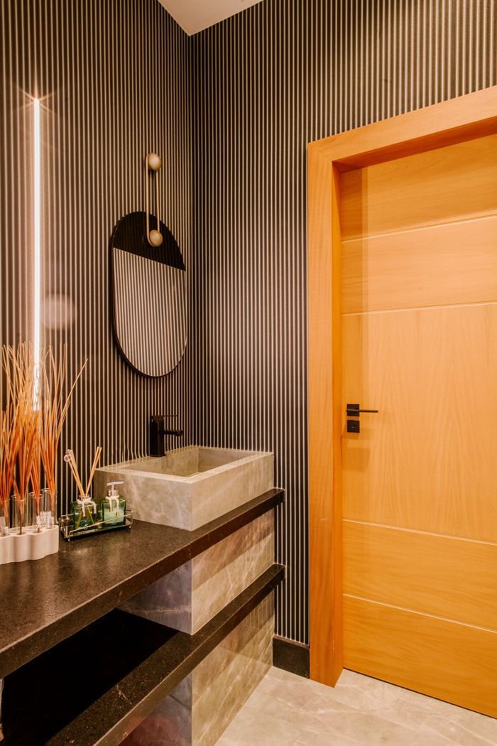 Stylish bathroom featuring a modern mirror, sleek sink, and wooden door.